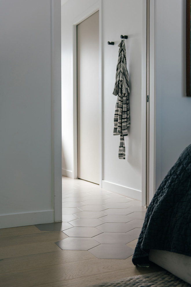 Cette photo montre une petite chambre parentale scandinave avec un mur blanc, un sol en carrelage de porcelaine et un sol gris.