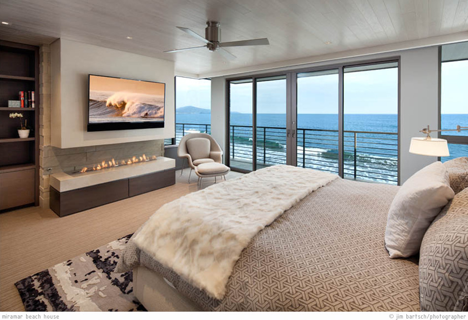 Mittelgroßes Modernes Hauptschlafzimmer mit grauer Wandfarbe, Teppichboden, Gaskamin, Kaminumrandung aus Stein und beigem Boden in Santa Barbara