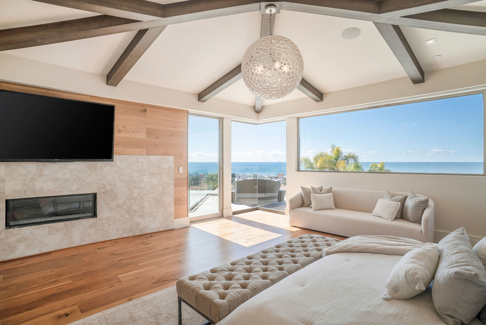 サンディエゴにある広いコンテンポラリースタイルのおしゃれな主寝室 (白い壁、無垢フローリング、標準型暖炉、石材の暖炉まわり、茶色い床) のレイアウト