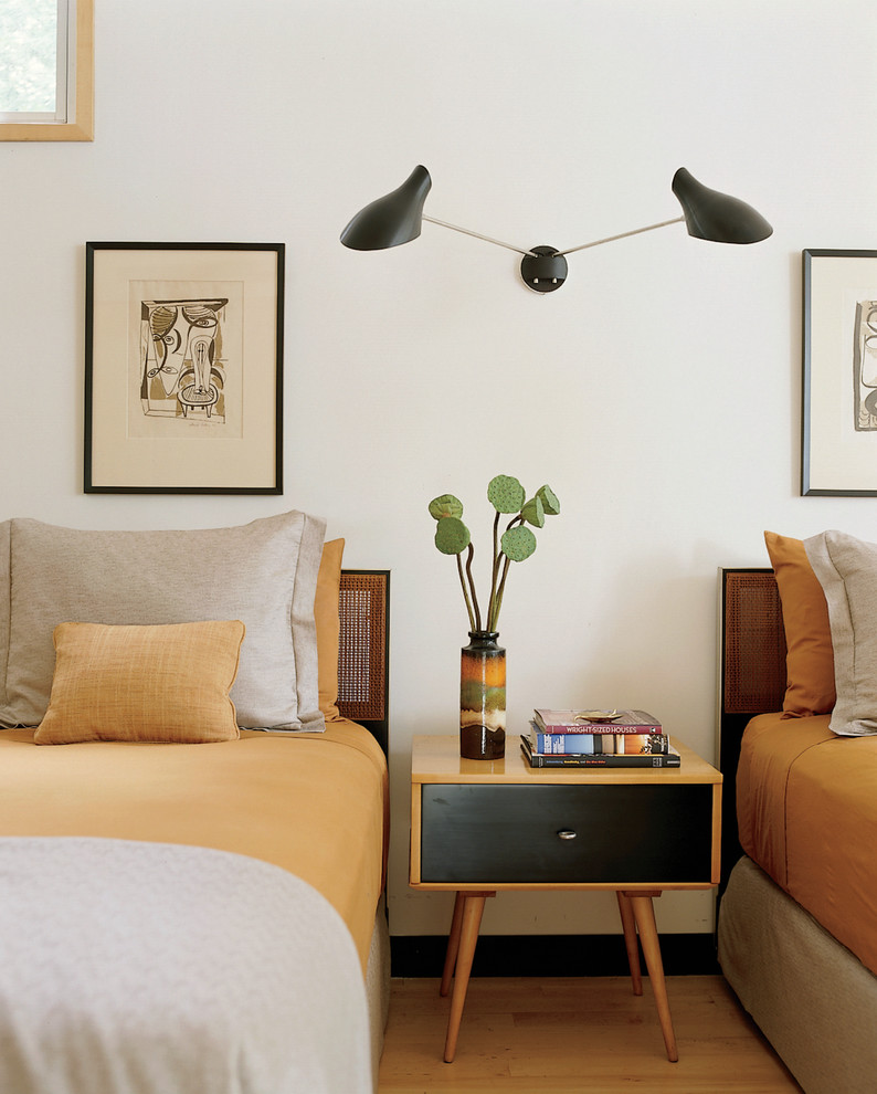 Immagine di una camera da letto minimalista con pareti bianche e abbinamento di mobili antichi e moderni