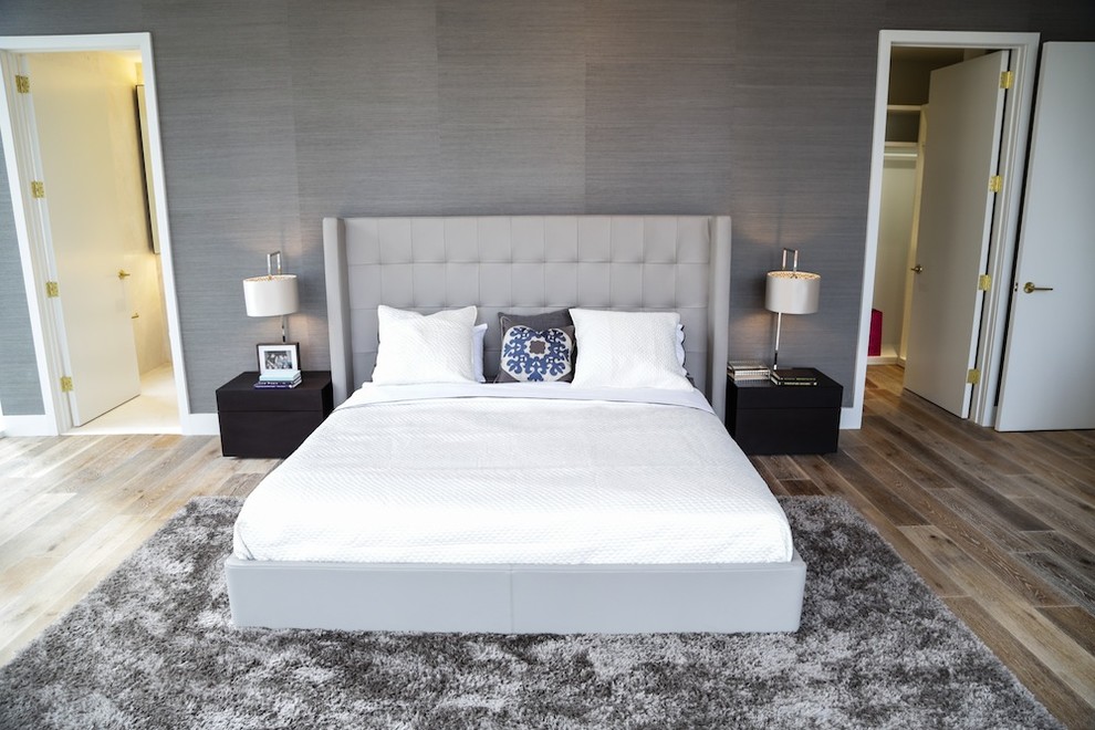 Modelo de dormitorio principal minimalista de tamaño medio con paredes blancas y suelo de madera clara