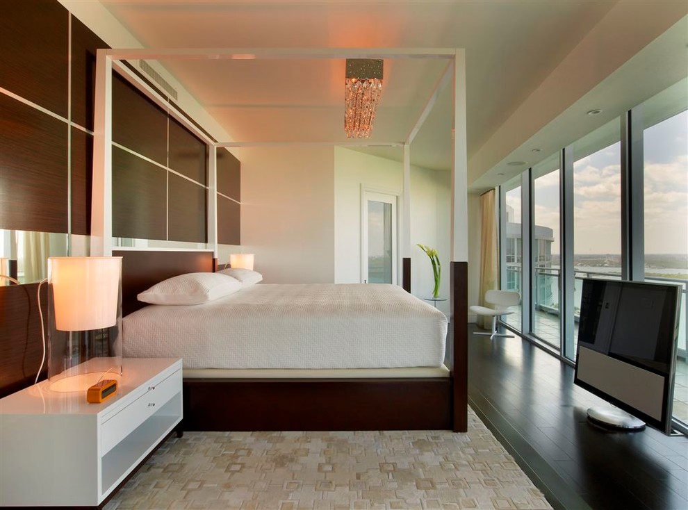 Inspiration for a contemporary bedroom in Miami with dark hardwood flooring.