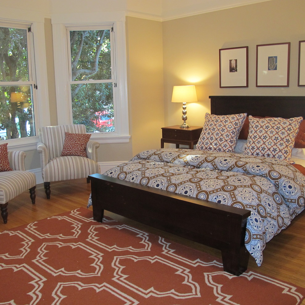 Modelo de dormitorio minimalista con paredes beige y suelo de madera en tonos medios