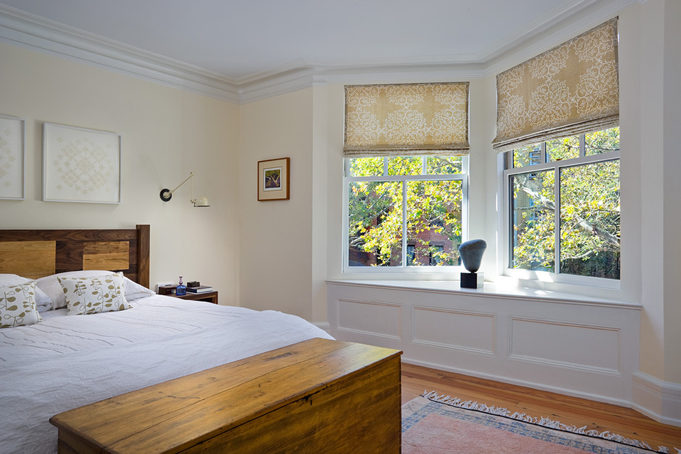 Immagine di una camera da letto chic con pareti beige e pavimento in legno massello medio
