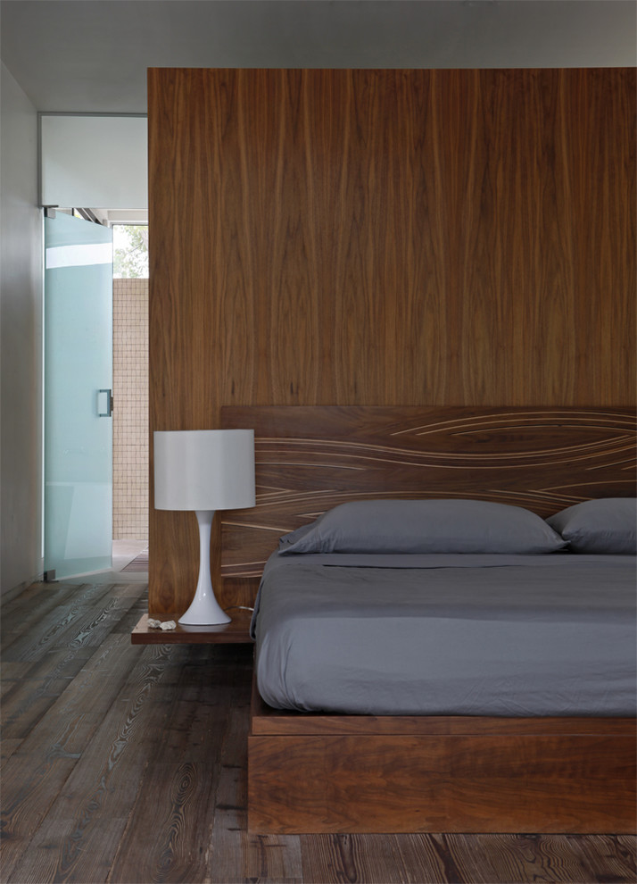 Bild på ett funkis sovrum, med mörkt trägolv och brunt golv