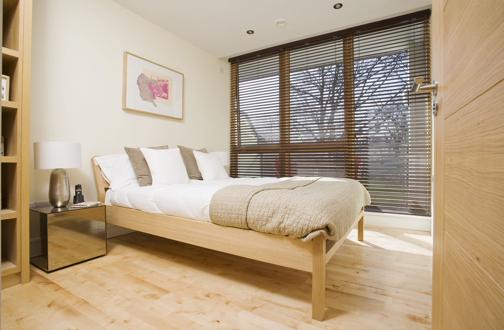 На фото: спальня в стиле модернизм с бежевыми стенами и светлым паркетным полом