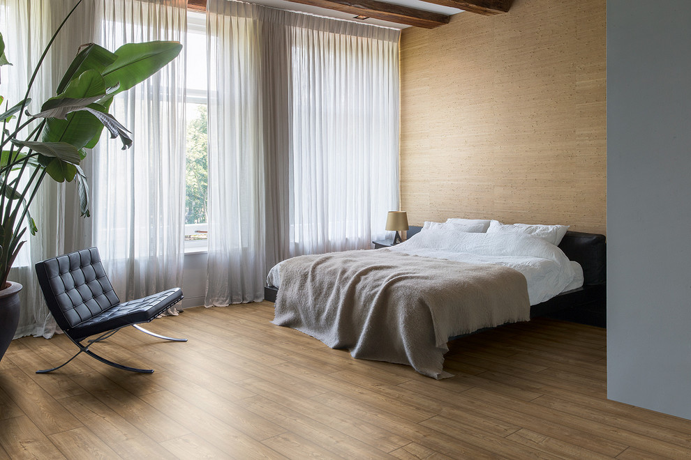 Foto de dormitorio minimalista con suelo laminado y suelo marrón