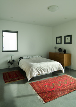 Ejemplo de habitación de invitados moderna de tamaño medio sin chimenea con paredes blancas y suelo de cemento