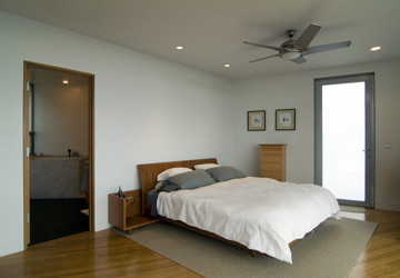 Imagen de dormitorio principal minimalista sin chimenea con paredes blancas y suelo de madera en tonos medios