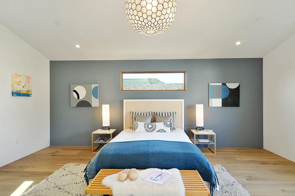Example of a large trendy master light wood floor bedroom design in San Francisco with blue walls