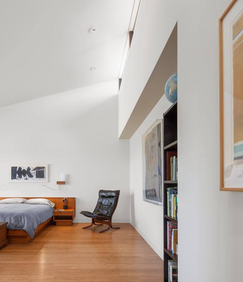 Foto di una camera da letto minimalista con pareti bianche, pavimento in legno massello medio e pavimento marrone