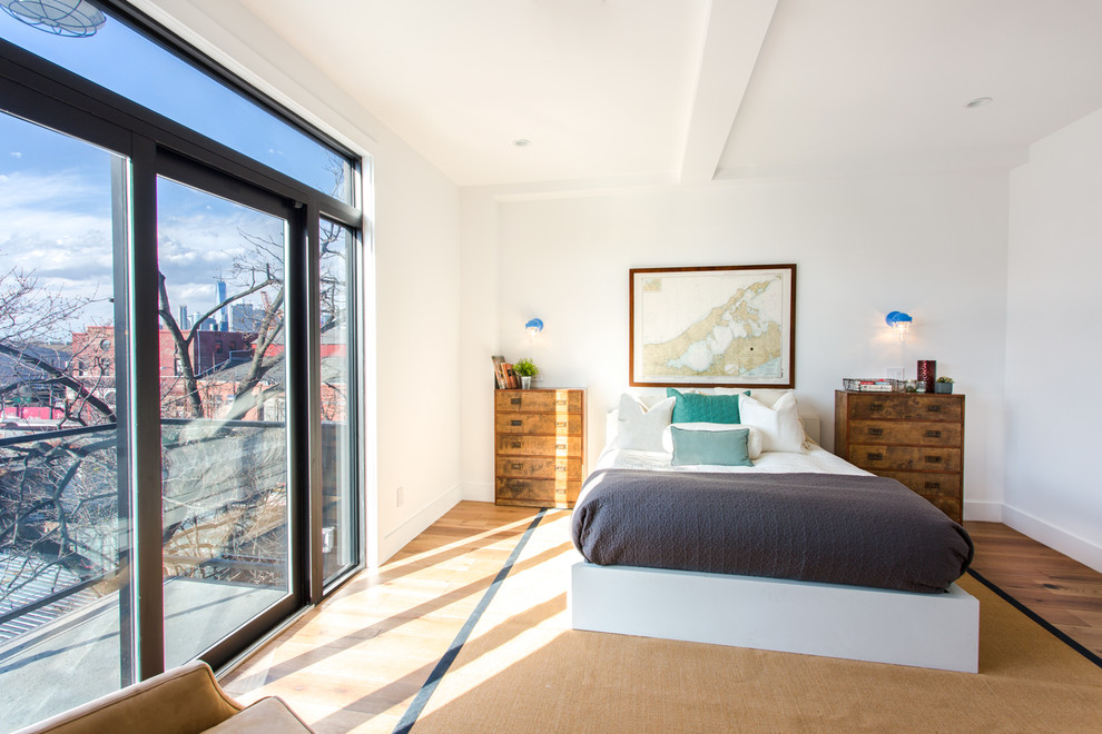 Diseño de dormitorio principal minimalista de tamaño medio sin chimenea con paredes blancas, suelo de madera clara y suelo beige