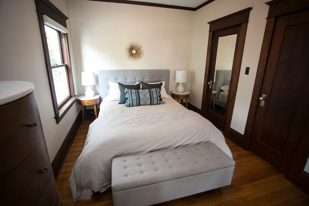 Immagine di una piccola camera matrimoniale minimalista con pareti beige e pavimento in legno massello medio