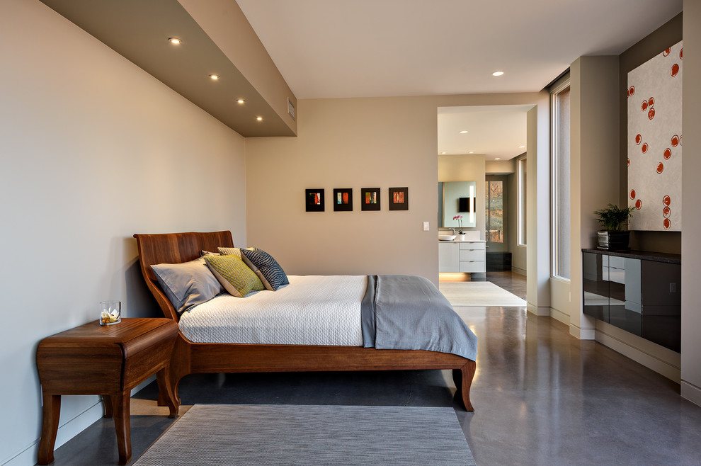 ソルトレイクシティにある中くらいなコンテンポラリースタイルのおしゃれな主寝室 (ベージュの壁、コンクリートの床、暖炉なし、グレーの床)