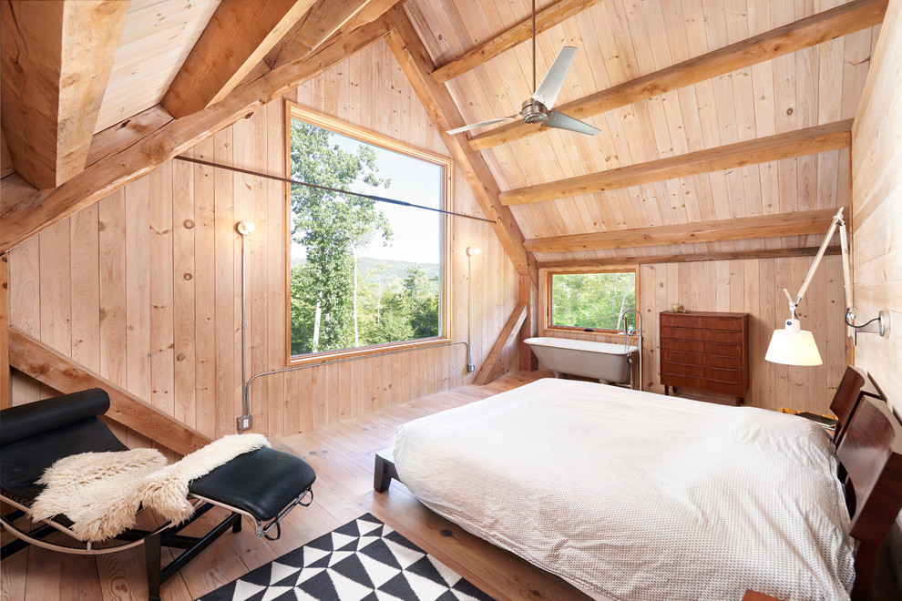 Rustic master loft bedroom in Portland Maine with light hardwood flooring.