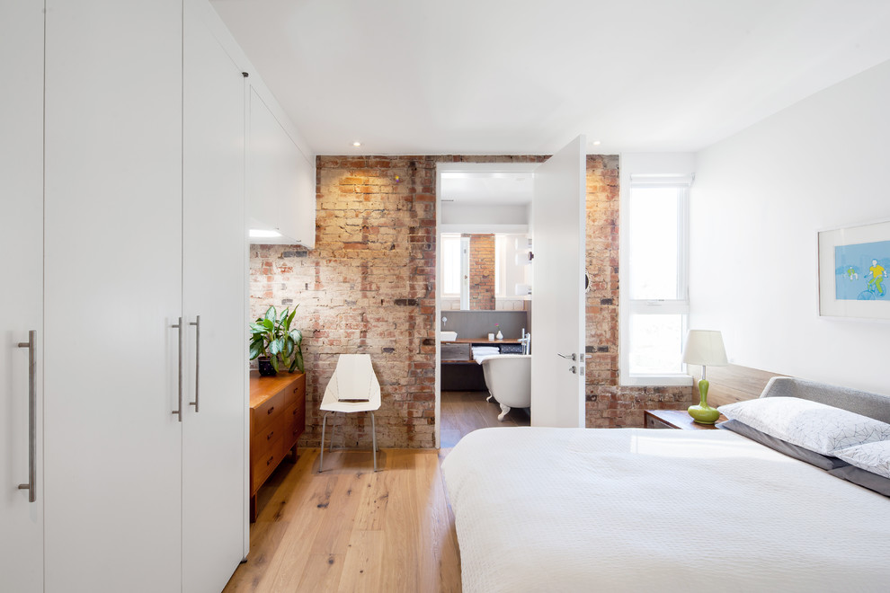 Пример оригинального дизайна: хозяйская спальня в стиле лофт с белыми стенами и светлым паркетным полом без камина