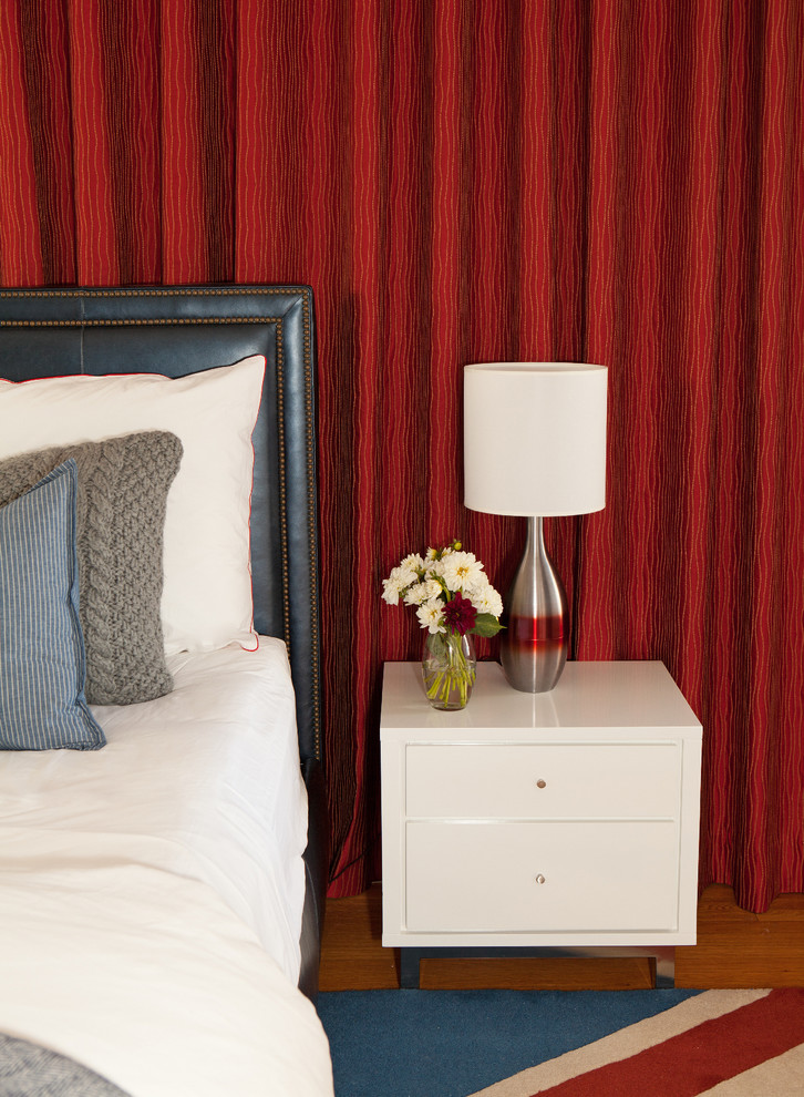 Ejemplo de dormitorio principal moderno de tamaño medio sin chimenea con paredes rojas y suelo de madera en tonos medios