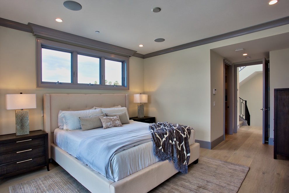 Photo of a medium sized contemporary master bedroom in Orange County with white walls, light hardwood flooring and multi-coloured floors.