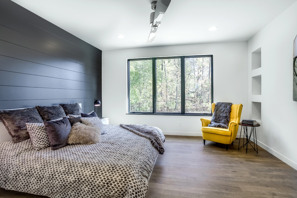 Imagen de dormitorio actual sin chimenea con paredes negras y suelo de madera clara