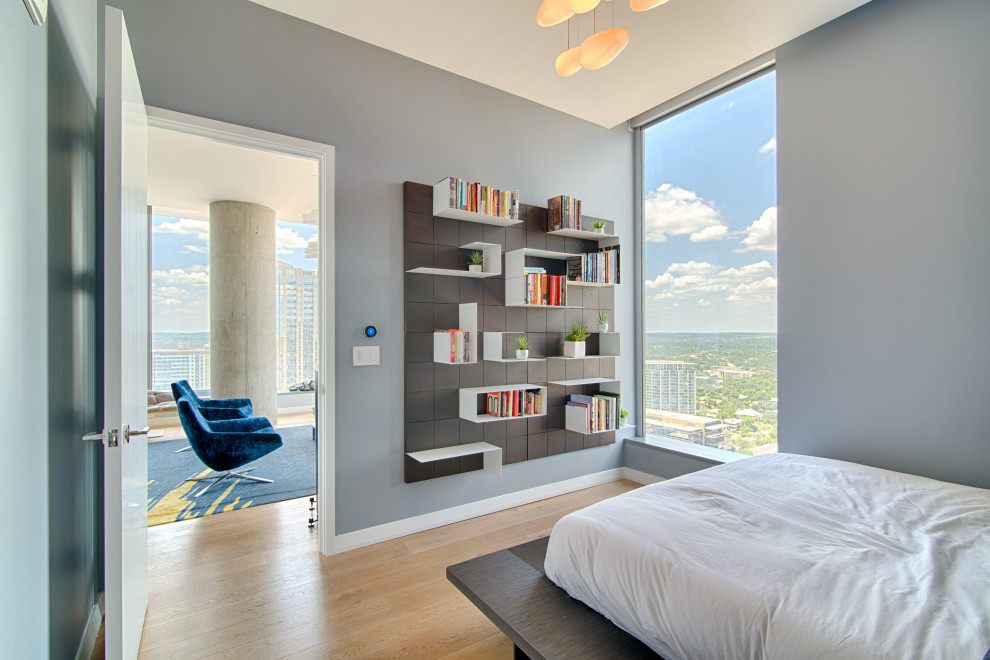 Small minimalist master light wood floor and brown floor bedroom photo in Austin with gray walls