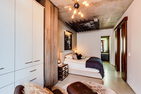Foto de dormitorio tipo loft minimalista grande sin chimenea con paredes grises, suelo de cemento y suelo gris