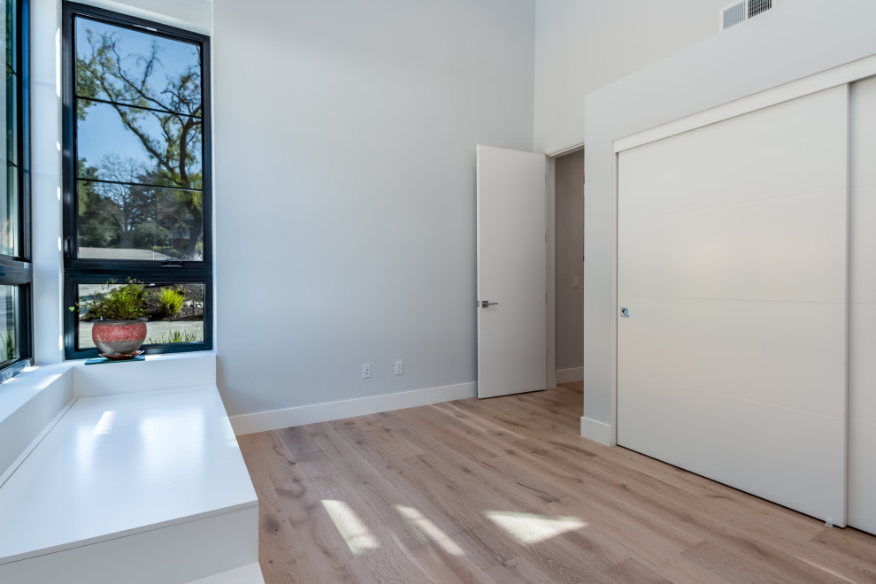 Großes Modernes Gästezimmer mit grauer Wandfarbe, hellem Holzboden und weißem Boden in San Francisco