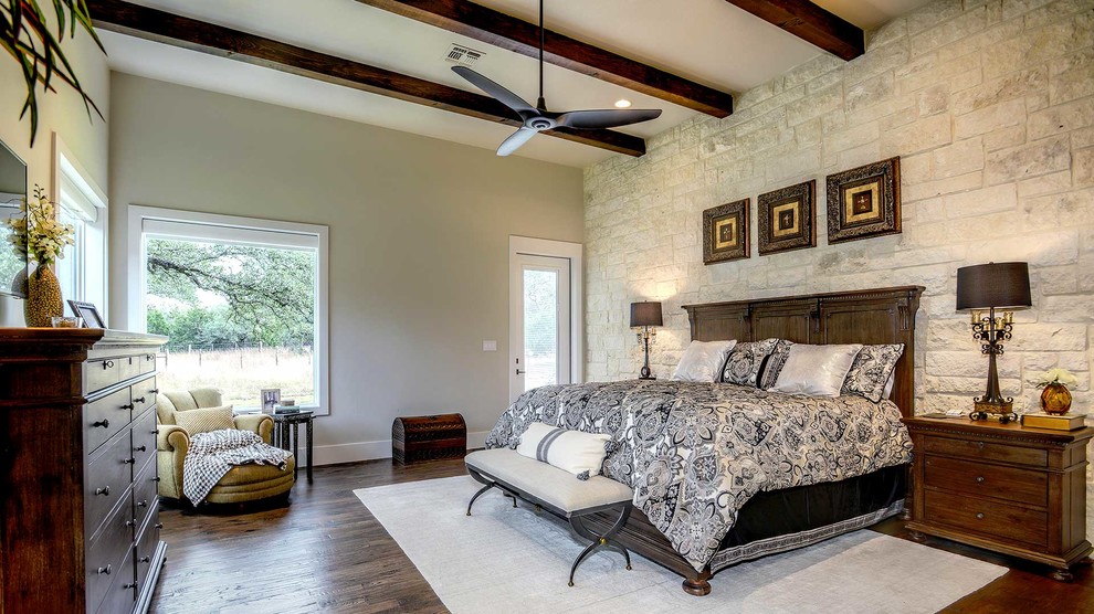 Großes Landhaus Hauptschlafzimmer ohne Kamin mit beiger Wandfarbe, braunem Holzboden und braunem Boden in Houston