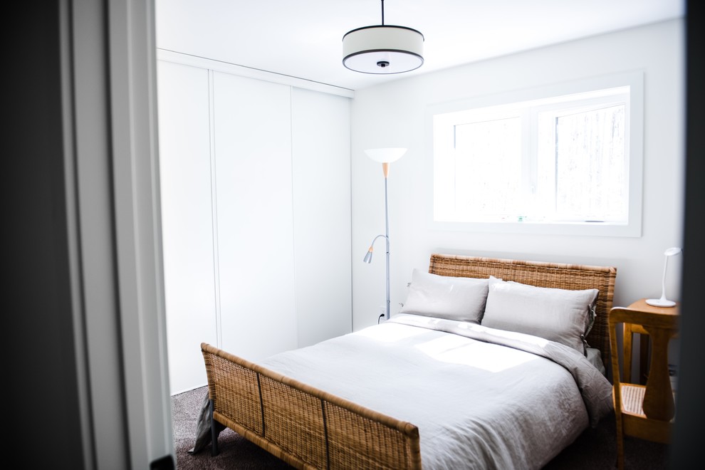 Foto de habitación de invitados moderna pequeña con paredes blancas, moqueta, chimenea de esquina y suelo marrón