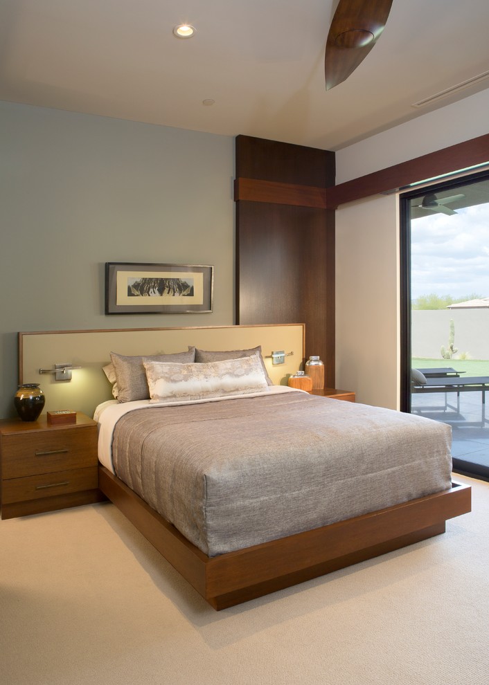 Стильный дизайн: большая хозяйская спальня в стиле модернизм с зелеными стенами, ковровым покрытием, подвесным камином, фасадом камина из камня и бежевым полом - последний тренд