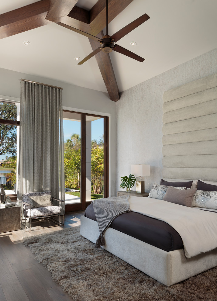 Diseño de dormitorio minimalista grande con paredes grises, suelo de madera oscura y suelo marrón