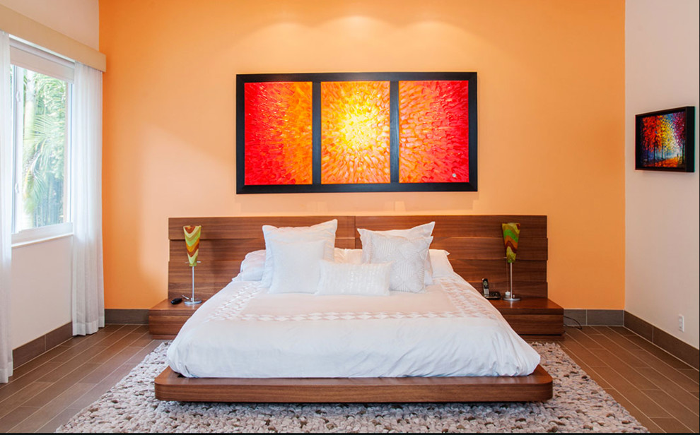 Mid-sized trendy guest porcelain tile and brown floor bedroom photo in Miami with orange walls and no fireplace
