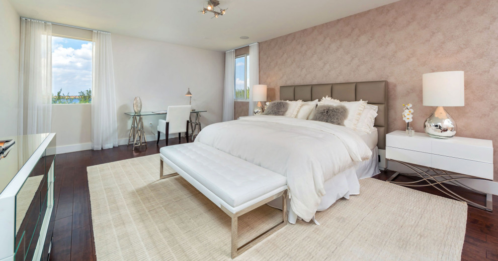 На фото: большая хозяйская спальня в стиле модернизм с розовыми стенами, полом из фанеры и коричневым полом с