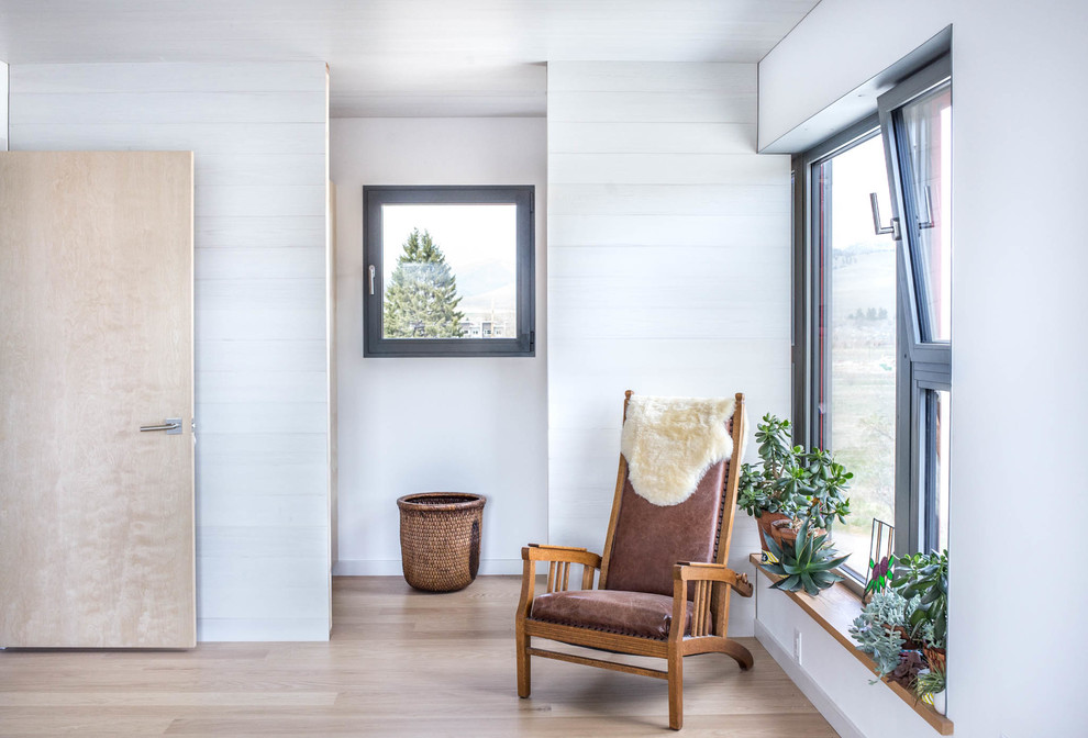 Modelo de habitación de invitados escandinava de tamaño medio con paredes blancas y suelo de madera clara