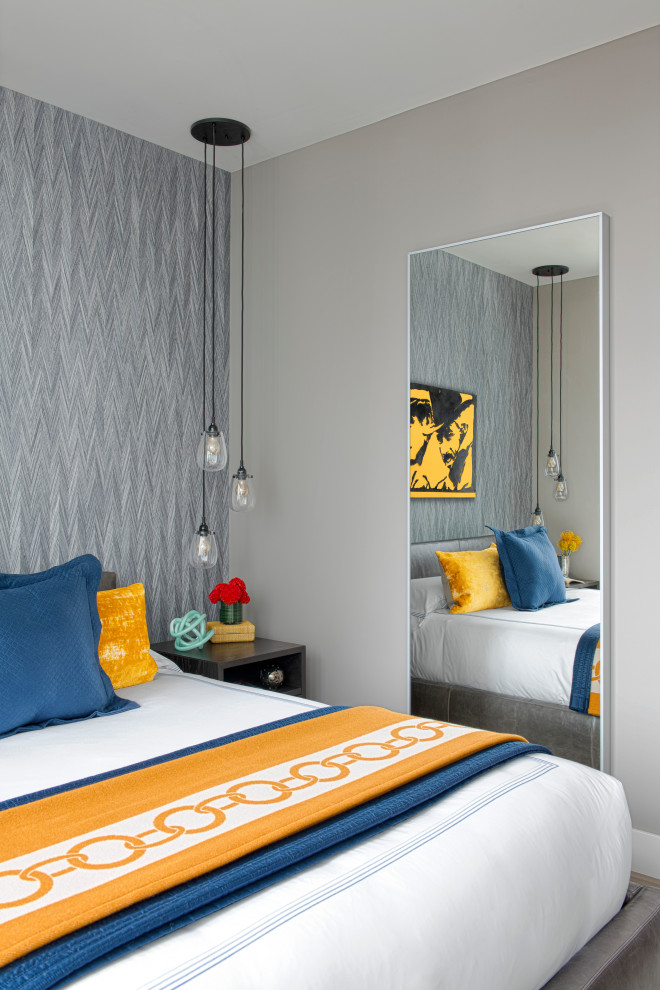Small modern guest bedroom in Boston with blue walls, medium hardwood flooring, grey floors and wallpapered walls.