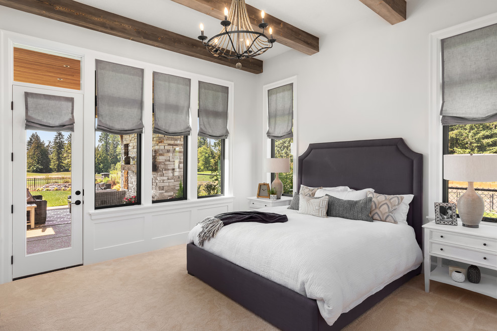 Photo of a large country master bedroom in Portland with white walls, carpet and beige floors.