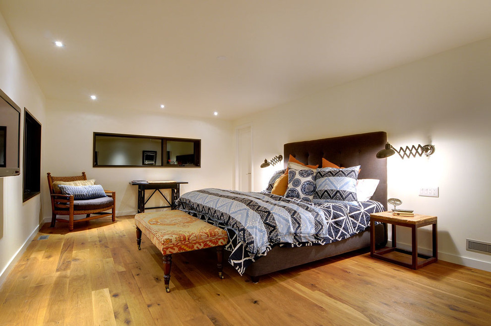 Ejemplo de dormitorio campestre con paredes blancas y suelo de madera en tonos medios