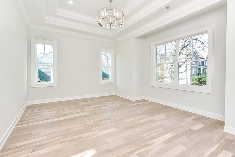Großes Landhausstil Hauptschlafzimmer ohne Kamin mit grauer Wandfarbe, hellem Holzboden und beigem Boden in Atlanta
