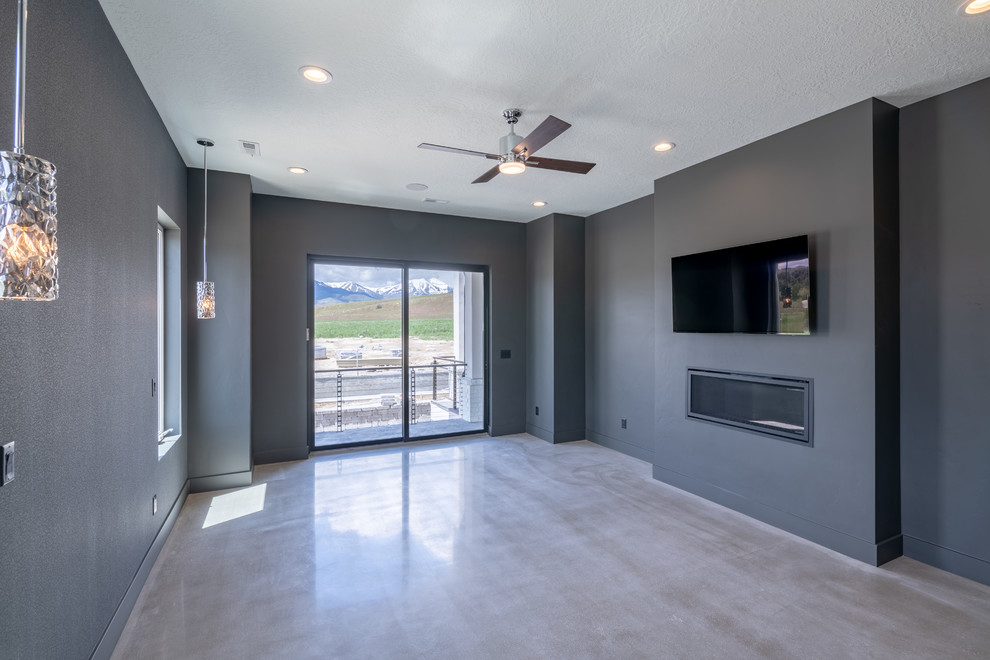 Large country master concrete floor and gray floor bedroom photo in Salt Lake City with black walls, a standard fireplace and a plaster fireplace