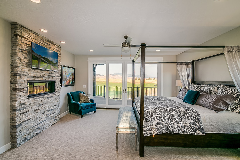 This is an example of a large farmhouse master bedroom in Other with grey walls, carpet, a ribbon fireplace, a stone fireplace surround and grey floors.