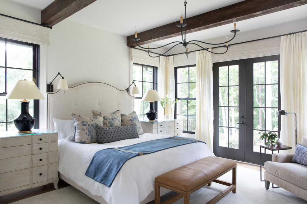 This is an example of a large farmhouse master bedroom in Atlanta with white walls, no fireplace, light hardwood flooring and beige floors.