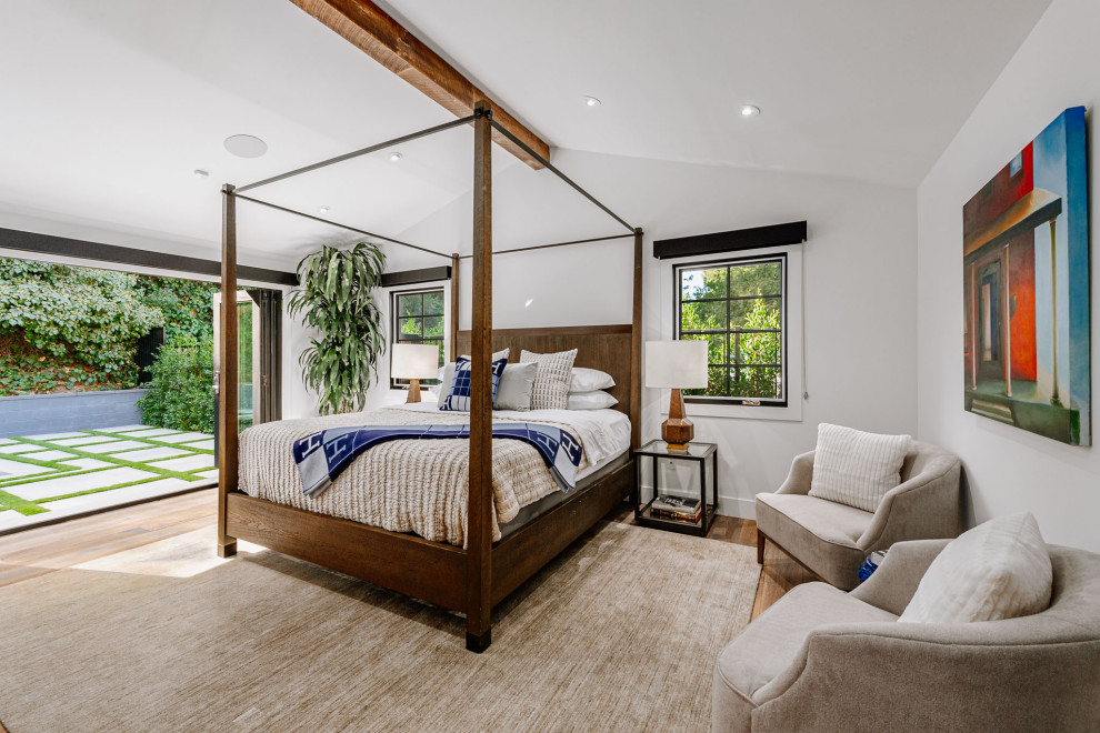 Cette photo montre une chambre parentale nature de taille moyenne avec un mur blanc et un sol en bois brun.
