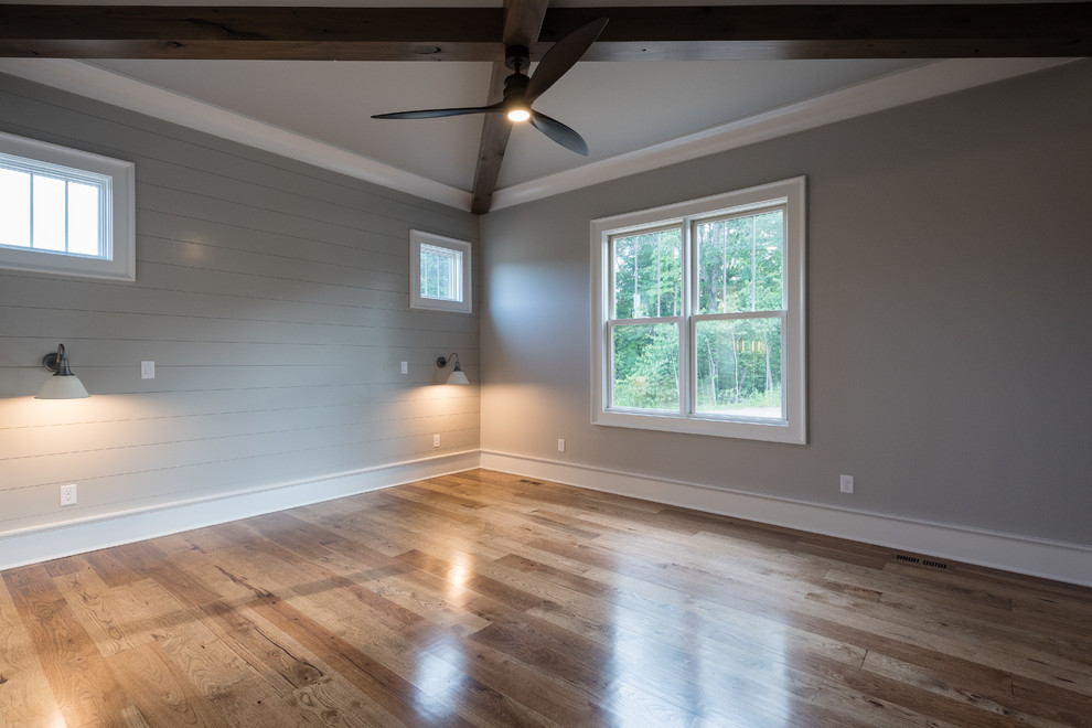 Imagen de dormitorio principal campestre de tamaño medio sin chimenea con paredes grises, suelo de madera oscura y suelo marrón
