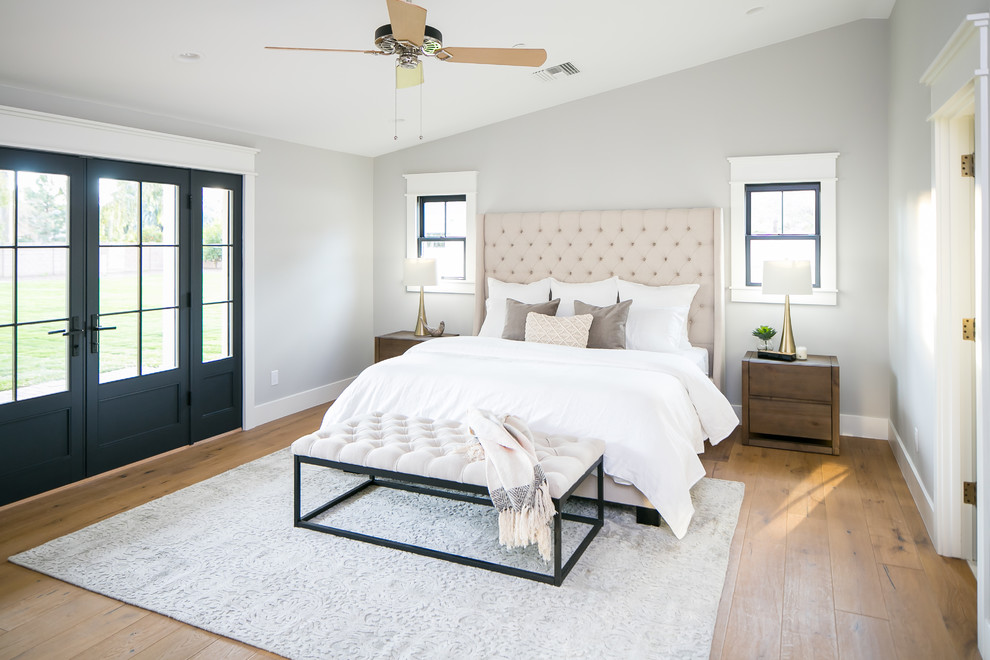Imagen de dormitorio principal de estilo de casa de campo de tamaño medio con suelo de madera en tonos medios
