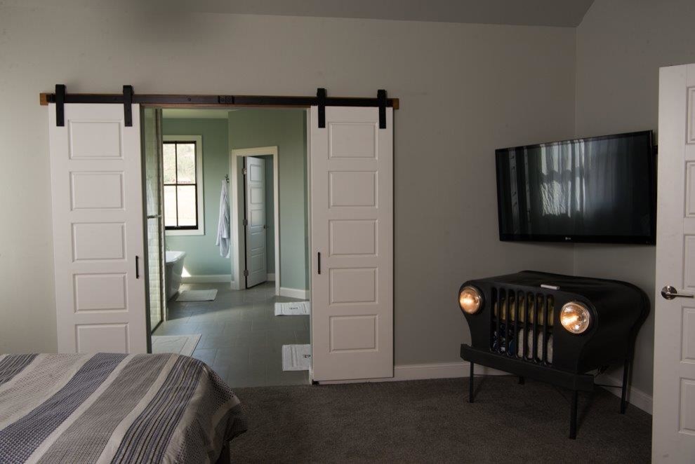 Modelo de dormitorio principal de estilo de casa de campo de tamaño medio sin chimenea con paredes grises, moqueta y suelo gris