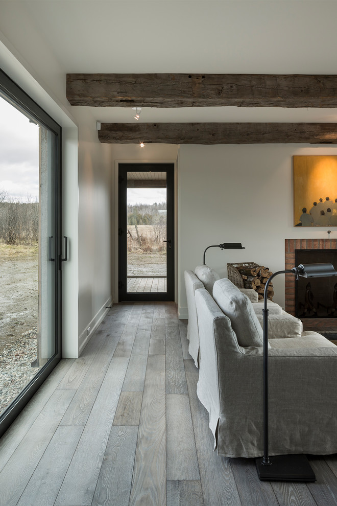 Country Schlafzimmer mit braunem Holzboden und grauem Boden in Montreal