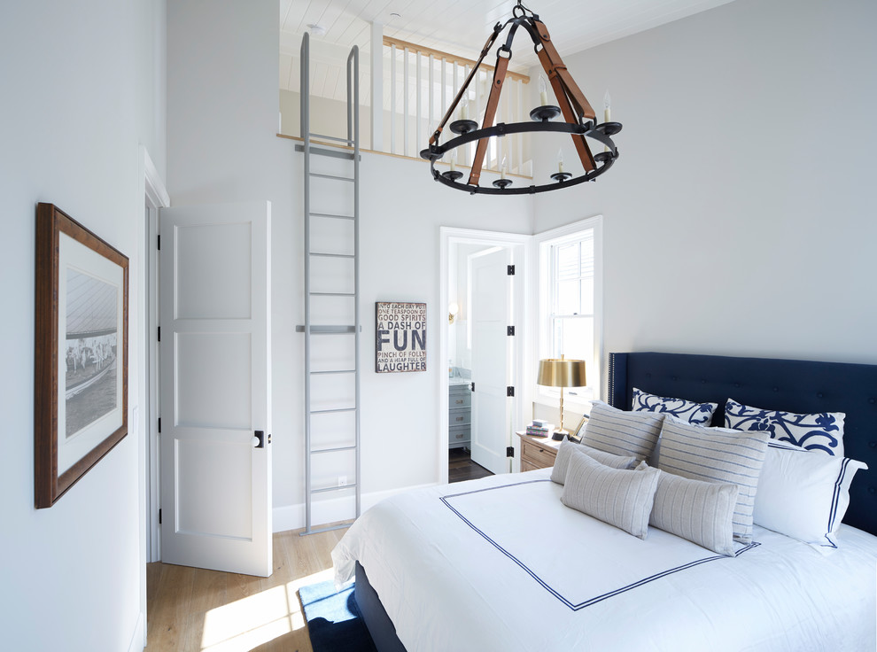 Стильный дизайн: гостевая спальня среднего размера, (комната для гостей) на мансарде в стиле кантри с белыми стенами, паркетным полом среднего тона и коричневым полом без камина - последний тренд