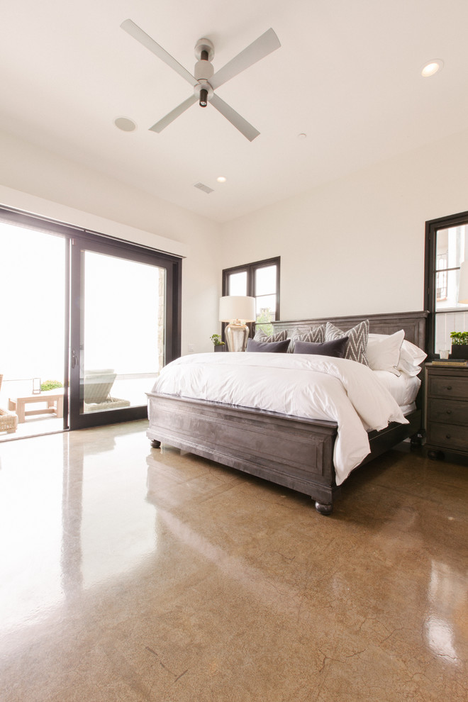 Photo of a contemporary master bedroom in Orange County with white walls and concrete flooring.