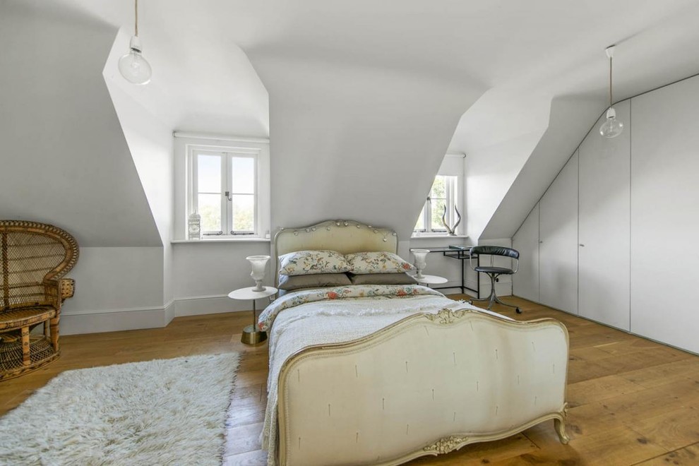 Photo of a medium sized vintage bedroom in London with white walls, medium hardwood flooring and beige floors.