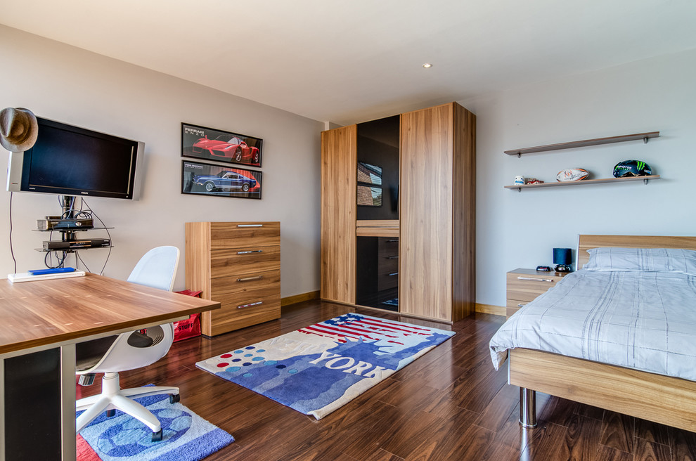 Ejemplo de habitación de invitados moderna de tamaño medio sin chimenea con paredes beige y suelo de madera en tonos medios