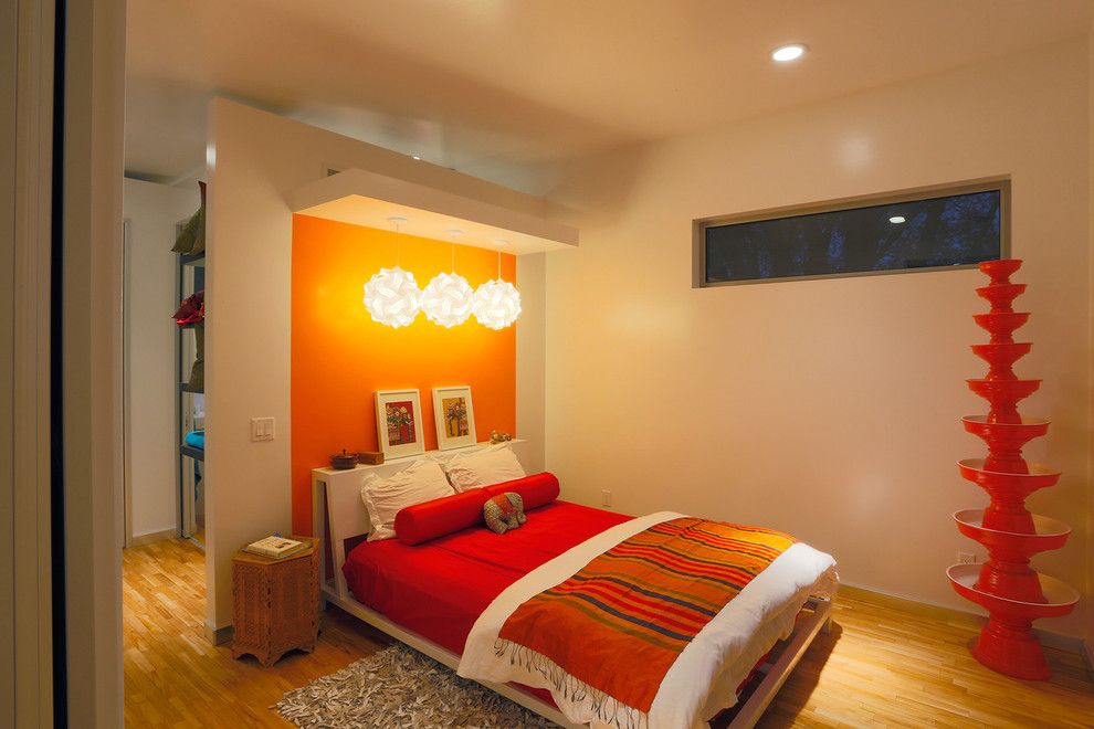 Imagen de dormitorio contemporáneo con parades naranjas